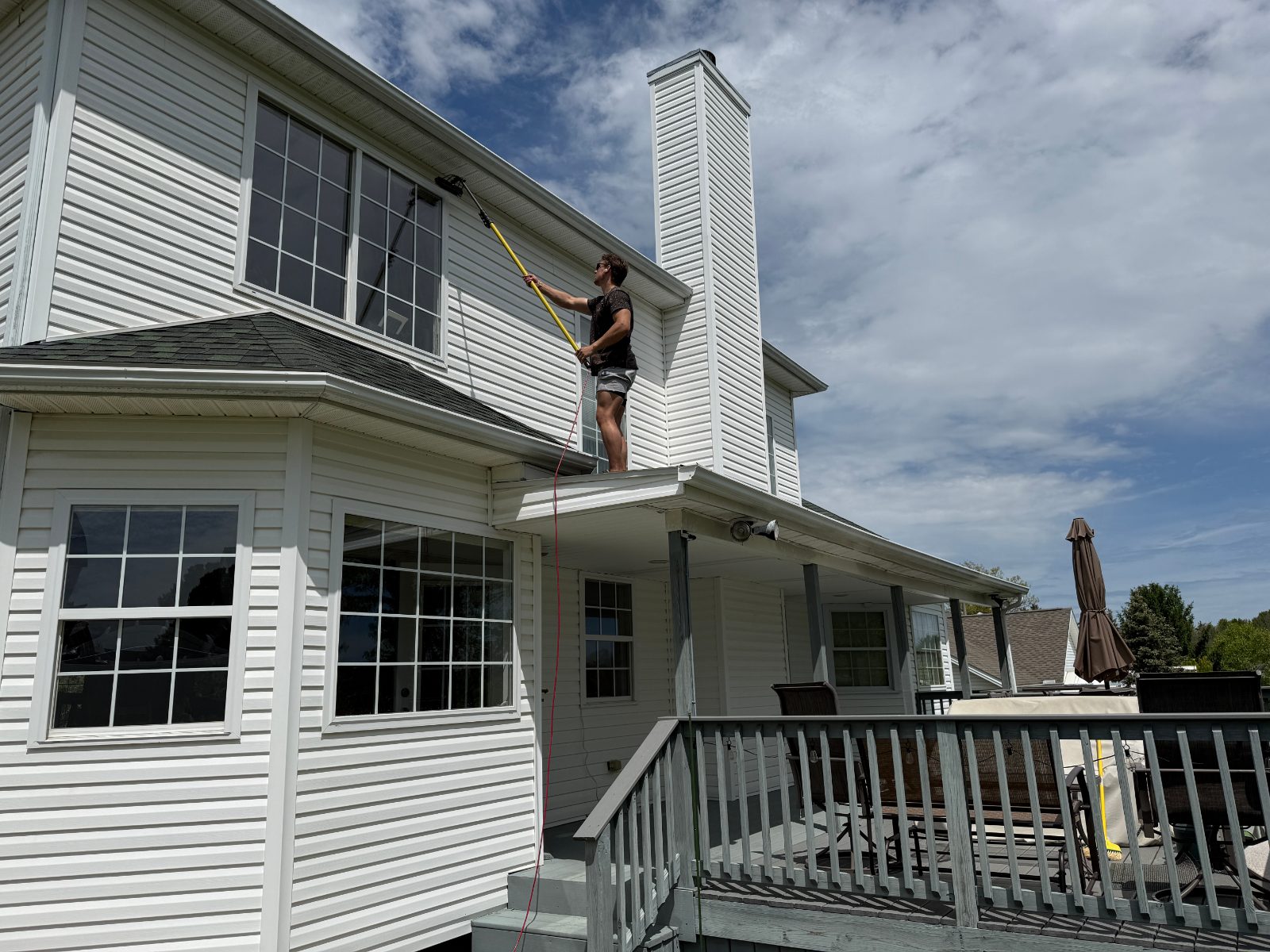 Grime Guyzz pressure washing siding on 2-story home